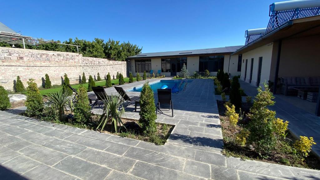 un patio con piscina y algunas sillas y árboles en Mughni Family House, en Ashtarak