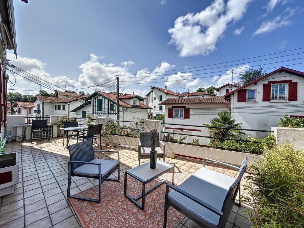 d'une terrasse avec des chaises, des tables et des maisons. dans l'établissement Appartement de charme Erdizka, à Bayonne