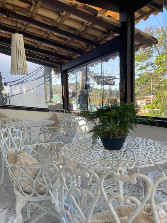 布希奧斯的住宿－Peixe Crew Centro，白色的桌子和椅子,上面有盆栽植物