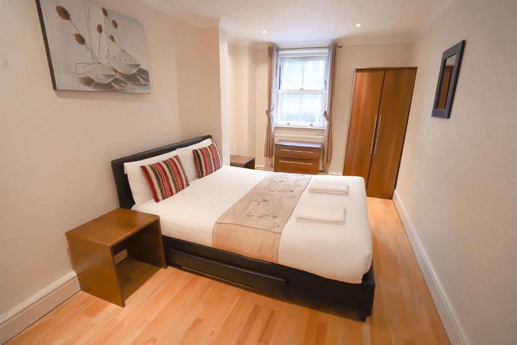 a bedroom with a large bed with a wooden floor at Cosy 2-Bed 2 Bathroom Apartment in London in London