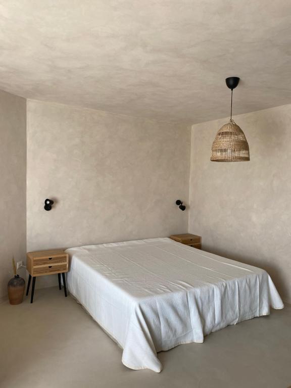 a bedroom with a white bed and a pendant light at STUDIO 33 South Pearl in Sozopol