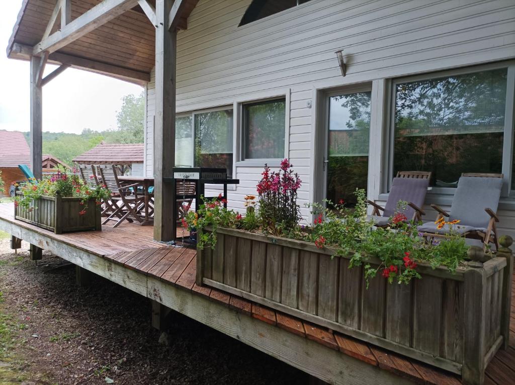 une terrasse couverte avec des plantes sur le côté d'une maison dans l'établissement La Douc'Heure, à Doucier