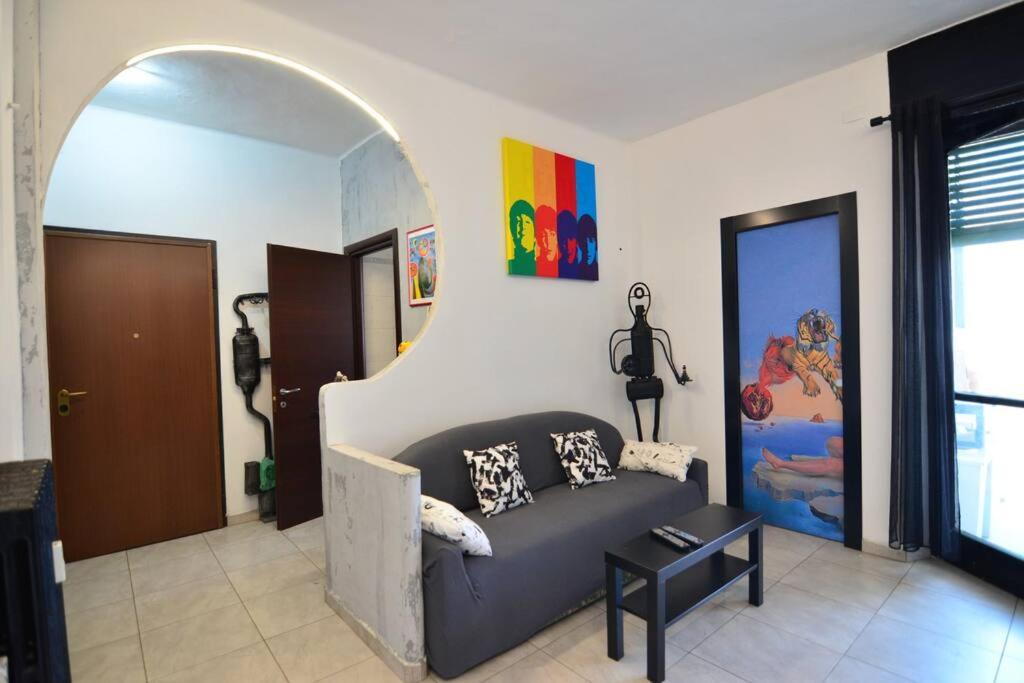PollyHouse - Apartment في تورينو: غرفة معيشة مع أريكة في غرفة مع قوس