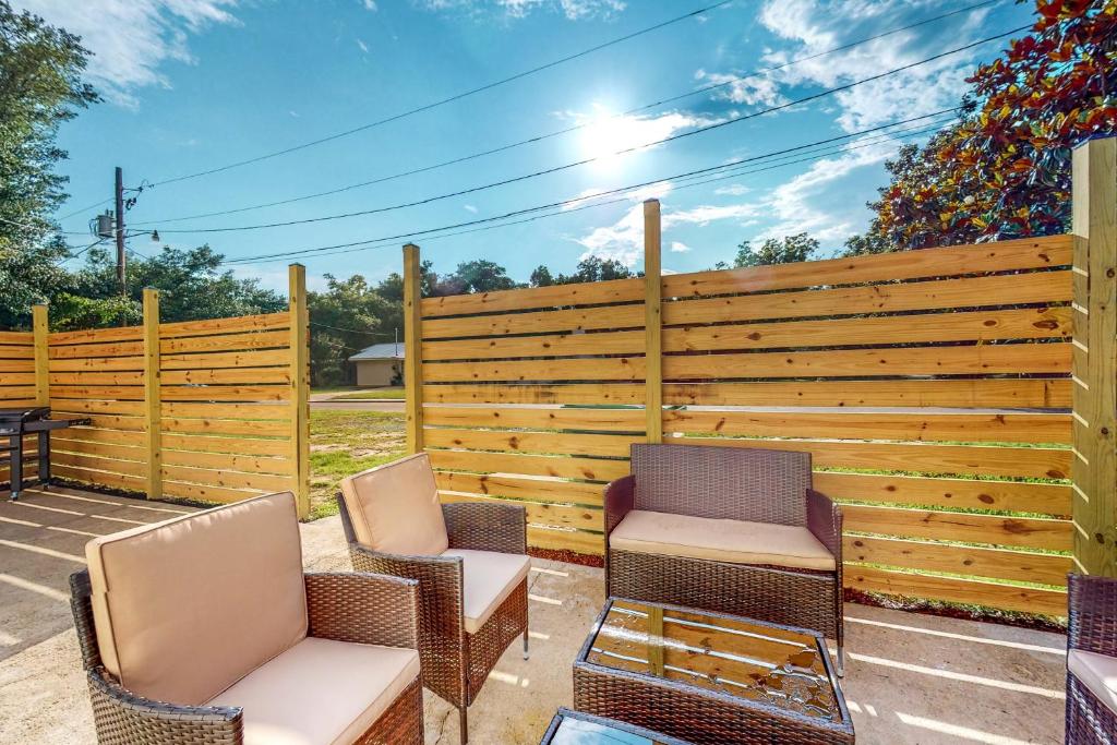 un patio con 2 sillas y una valla de madera en Old Town Bay Retreat, en Bay Saint Louis