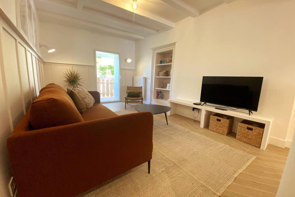 un soggiorno con divano e TV a schermo piatto di Lac's Lodge ¤ Maison coquette à 10min du lac ad Annecy