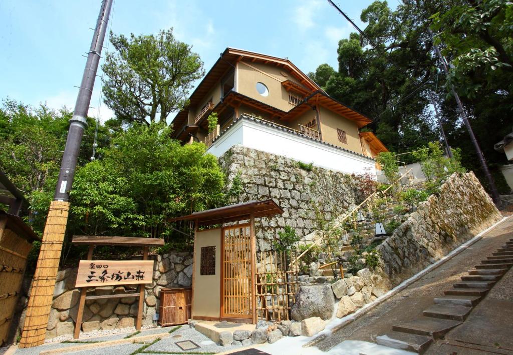 een klein gebouw met een bord ervoor bij Sanjoubou Sansou villa in Kyoto
