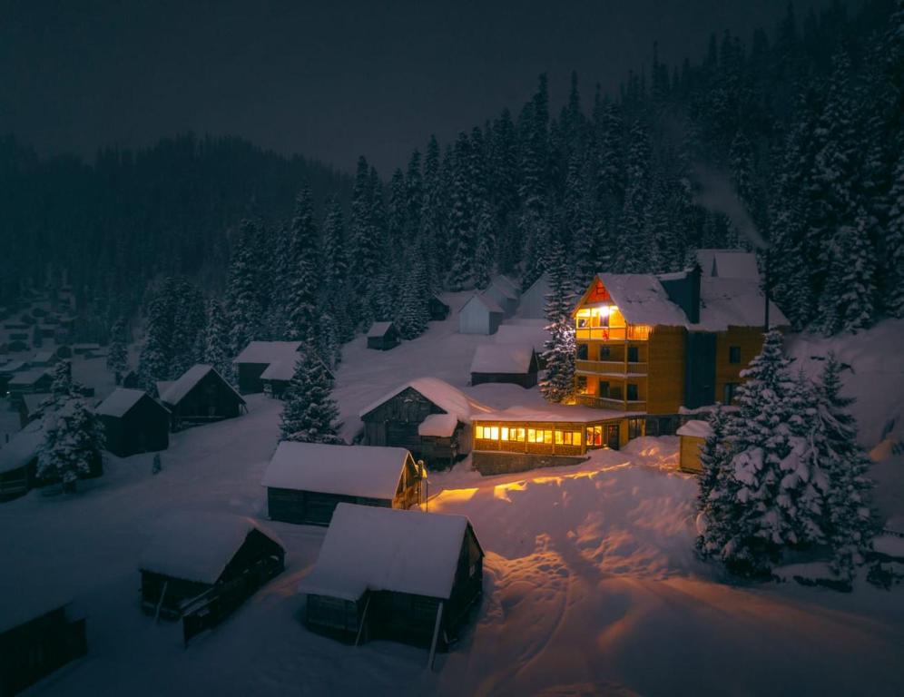 una casa con luces encendidas en la nieve por la noche en Panorama Bakhmaro, en Chʼkhakoura