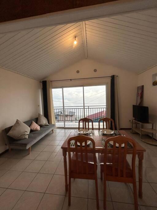 a living room with a table and two chairs at Appartement Le Tangor in Saint-Leu