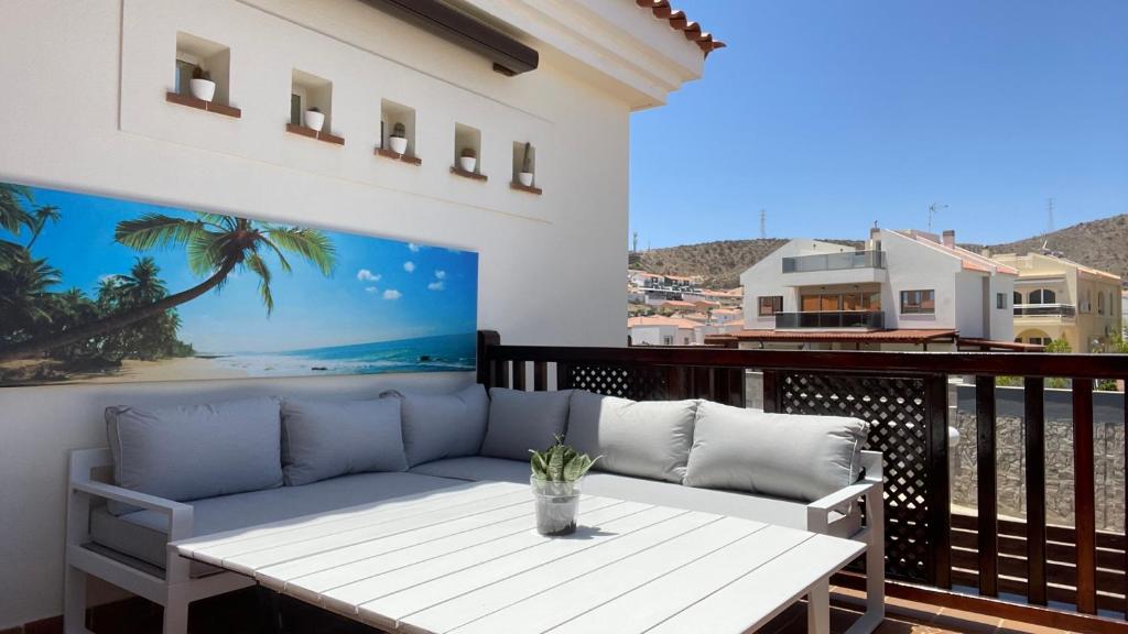 a patio with a couch and a table on a balcony at Selena Luxury Monte Carrera in La Playa de Arguineguín