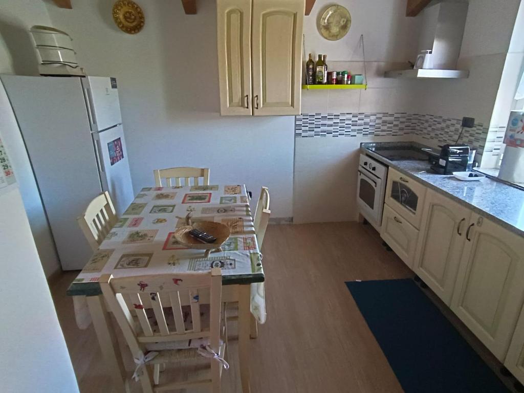 una cucina con tavolo, sedie e frigorifero di Casa Anna a Ceparana