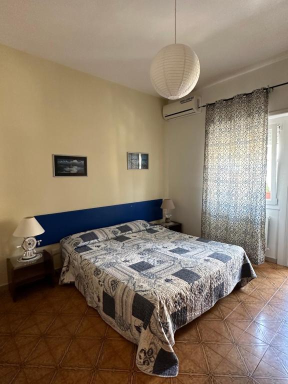 a bedroom with a bed with a blue headboard at Al Porto Di Roma B&B in Lido di Ostia