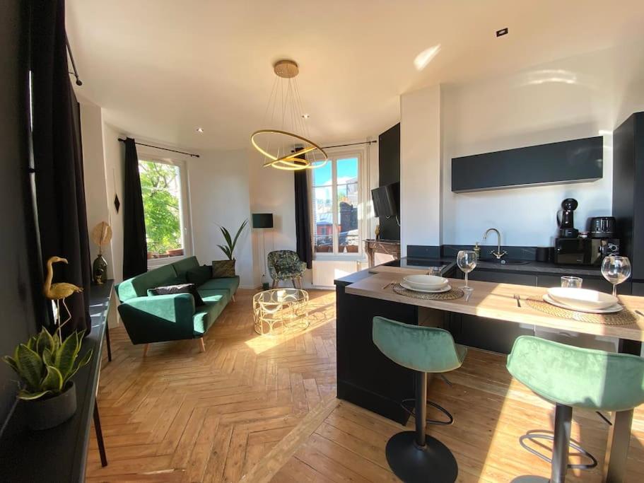 uma sala de estar com uma cozinha e uma sala de estar com um sofá em The Jungle Flat em Rouen