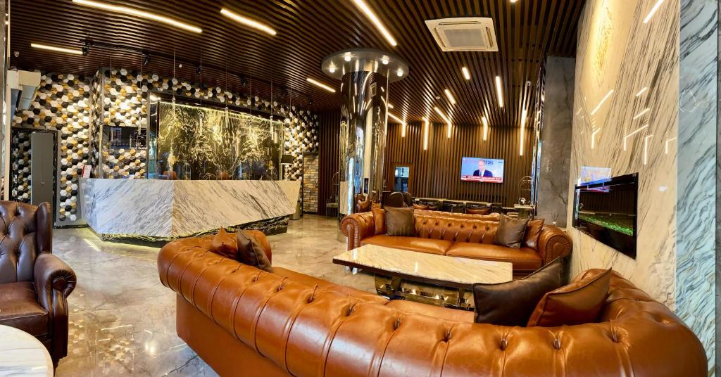 a living room with leather furniture and a large couch at Grand Hotel Basaran in Bilecik
