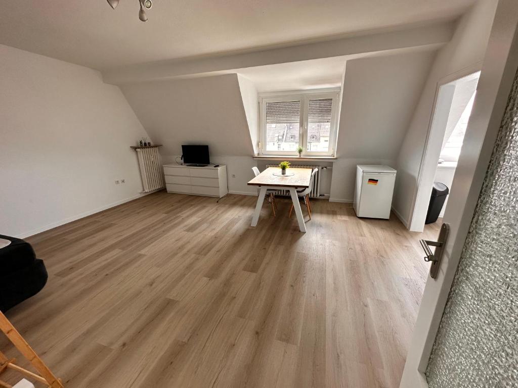 ein leeres Wohnzimmer mit einem Tisch in der Mitte in der Unterkunft Apartment City und Stadionnah I Privatparkplatz inklusive I in Dortmund