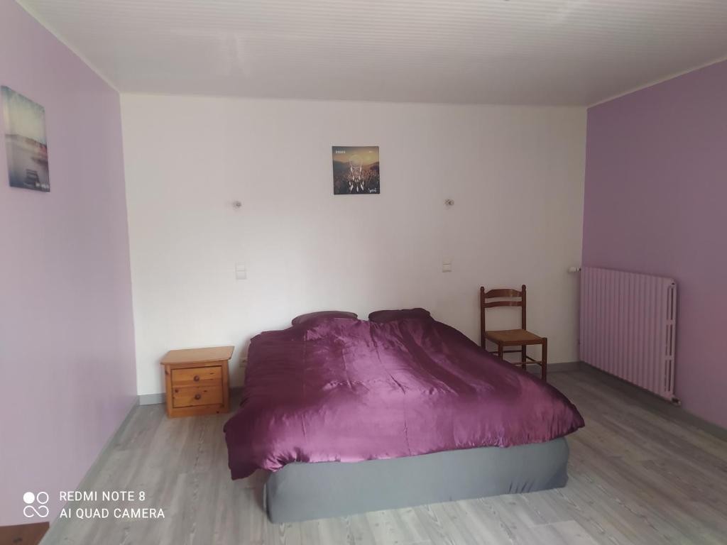 1 dormitorio con 1 cama de color púrpura y 1 silla en Maison de campagne, en Gourin