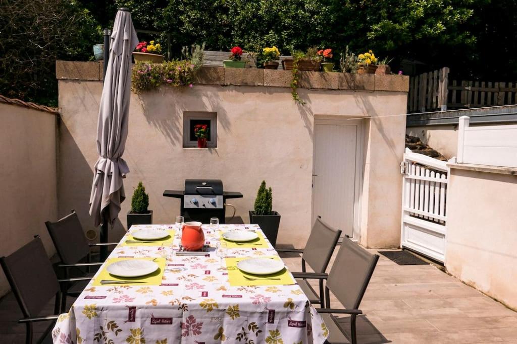 une table et des chaises avec une table et un parasol dans l'établissement Villa située entre mer et forêt, à Grand-Village-Plage