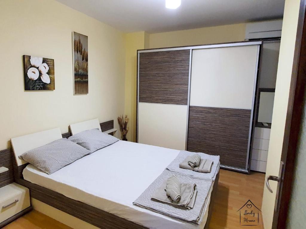 a bedroom with a bed and a large window at Lindy Home in Burgas