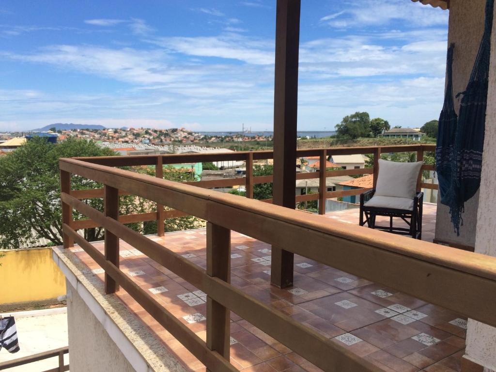 einen Balkon mit einem Stuhl und Stadtblick in der Unterkunft Cruzeiro in São Pedro da Aldeia