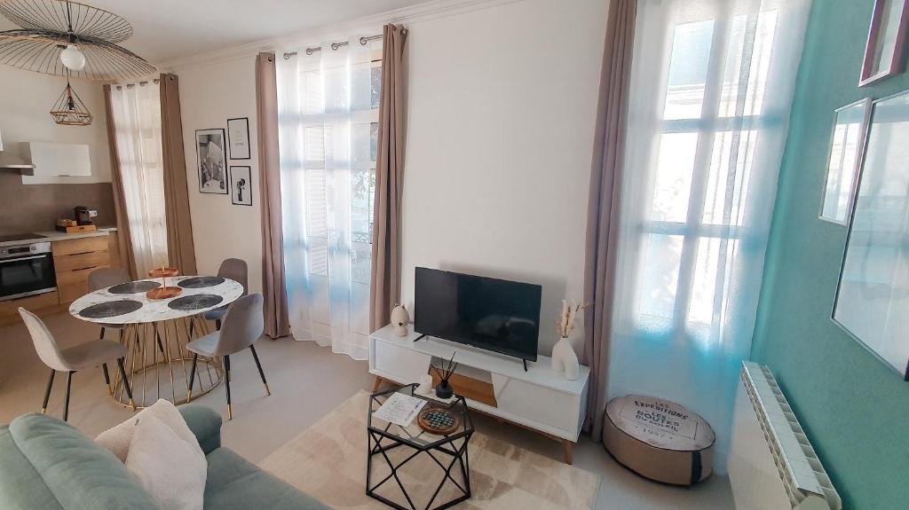 uma sala de estar com um sofá e uma mesa com uma televisão em Appartement T3 à deux pas du centre-ville em Vichy