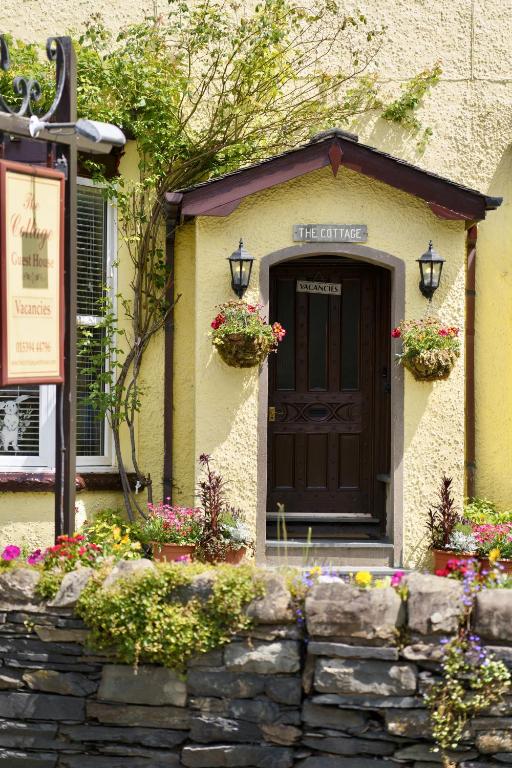 a building with a door and flowers in front of it at The Cottage - Room Only in Windermere
