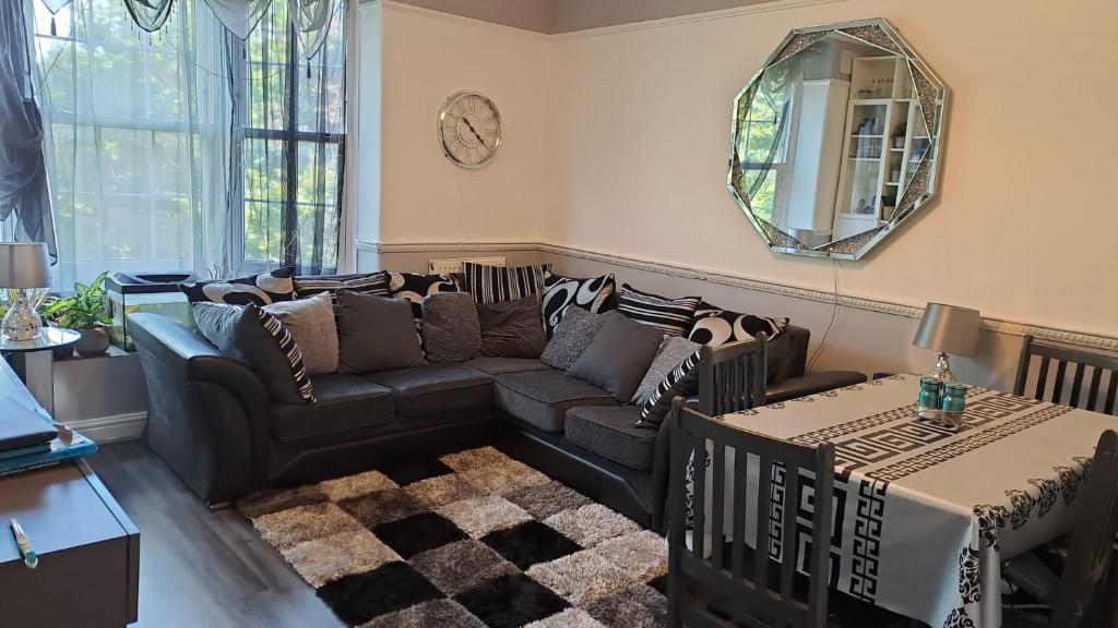 a living room with a couch and a mirror at 3 bedroom Brixton Apartment in London