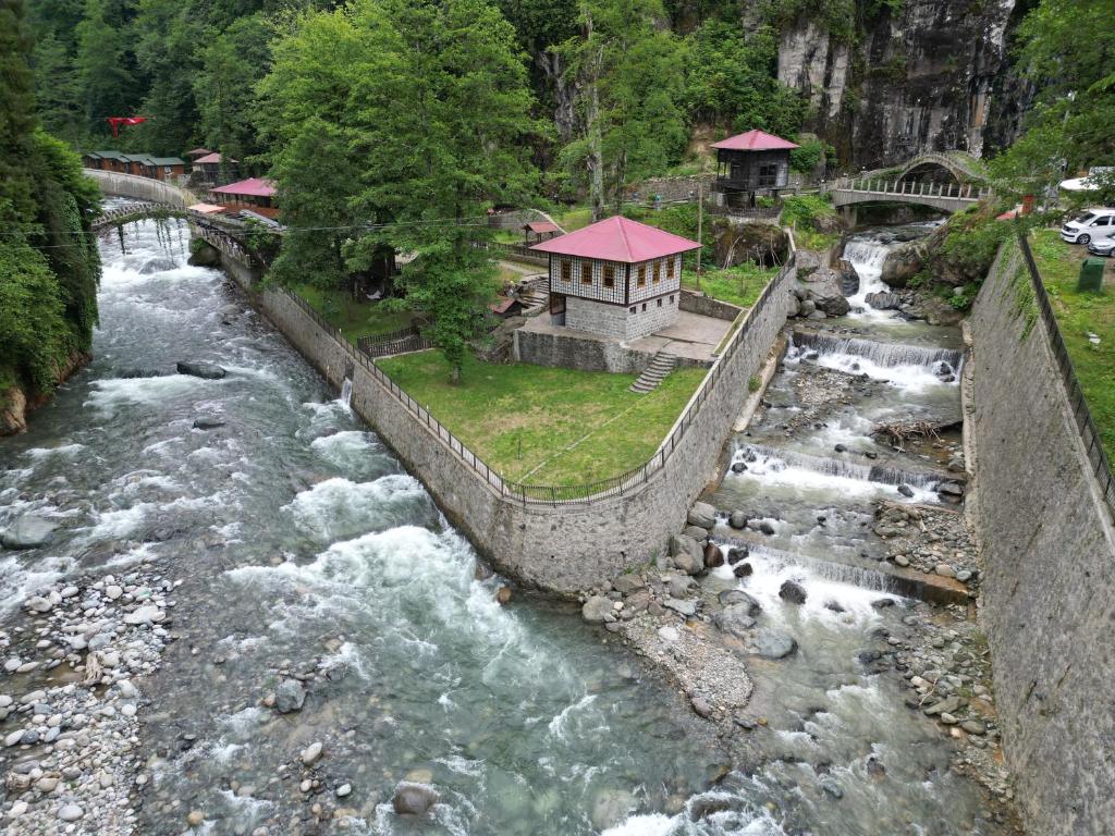 a river with a building in the middle of it at DERE AĞZI TATİL KÖYÜ in Rize