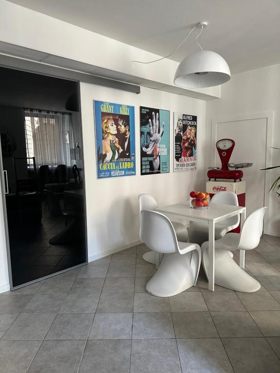a dining room with a table and chairs and posters at My Secret Room Apartment vicino al lago in Verbania
