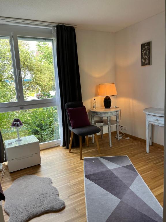 ein Wohnzimmer mit einem Schreibtisch und einem Fenster in der Unterkunft Oasi 2 in Kreuzlingen