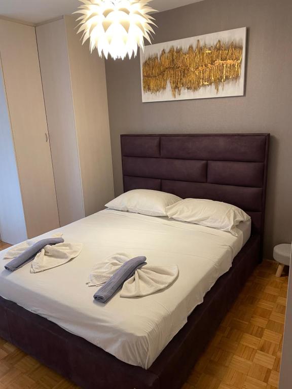 a bedroom with a large bed with a brown headboard at Apartment By The Center in Zadar