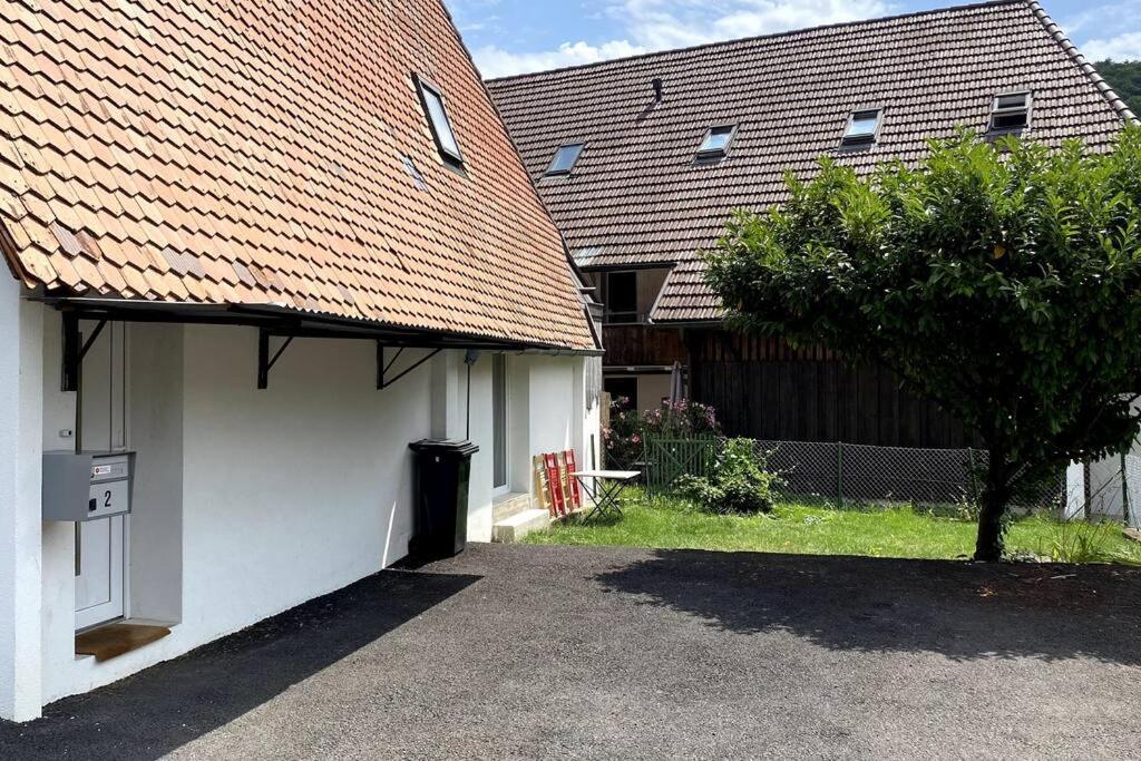 una casa blanca con un garaje y un árbol en triplex dans une ferme rénovée, en Gals