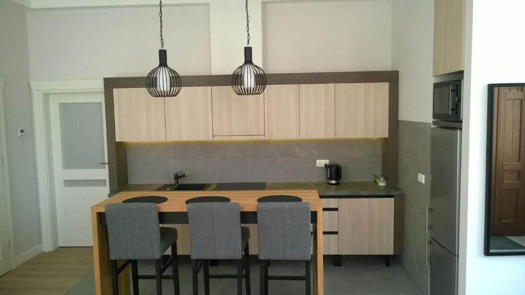 a kitchen with a table with chairs and two pendant lights at Kavo Sopot Apartment in Sopot