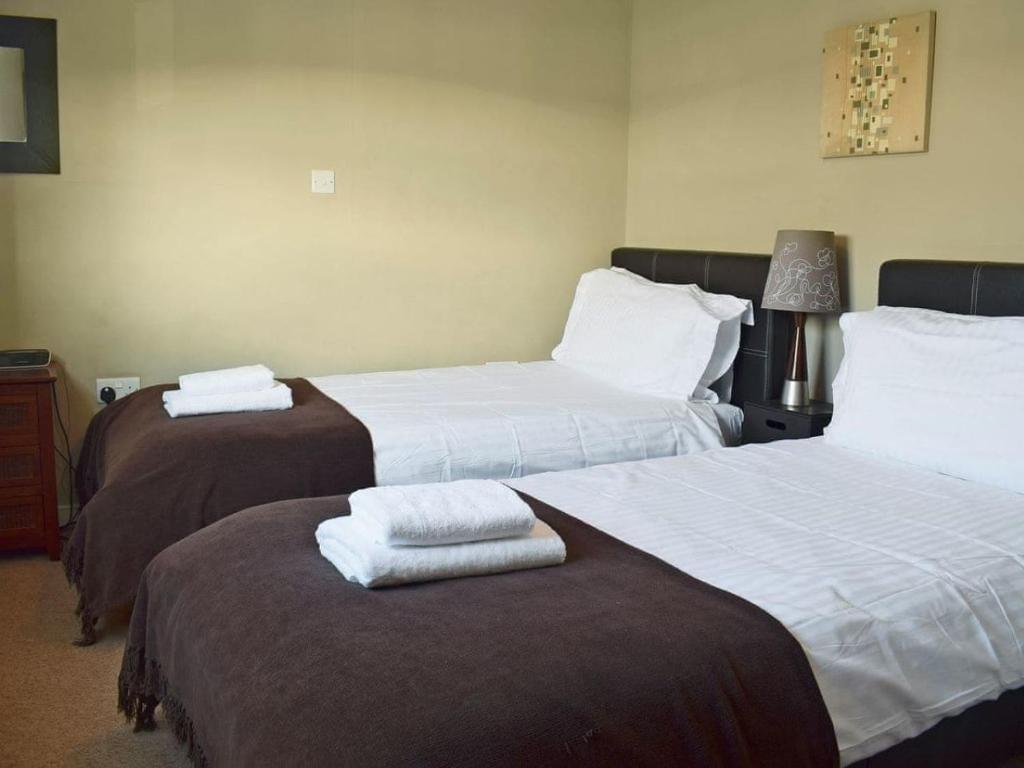 a hotel room with two beds with towels on them at Bell Island Cottage in Whitby