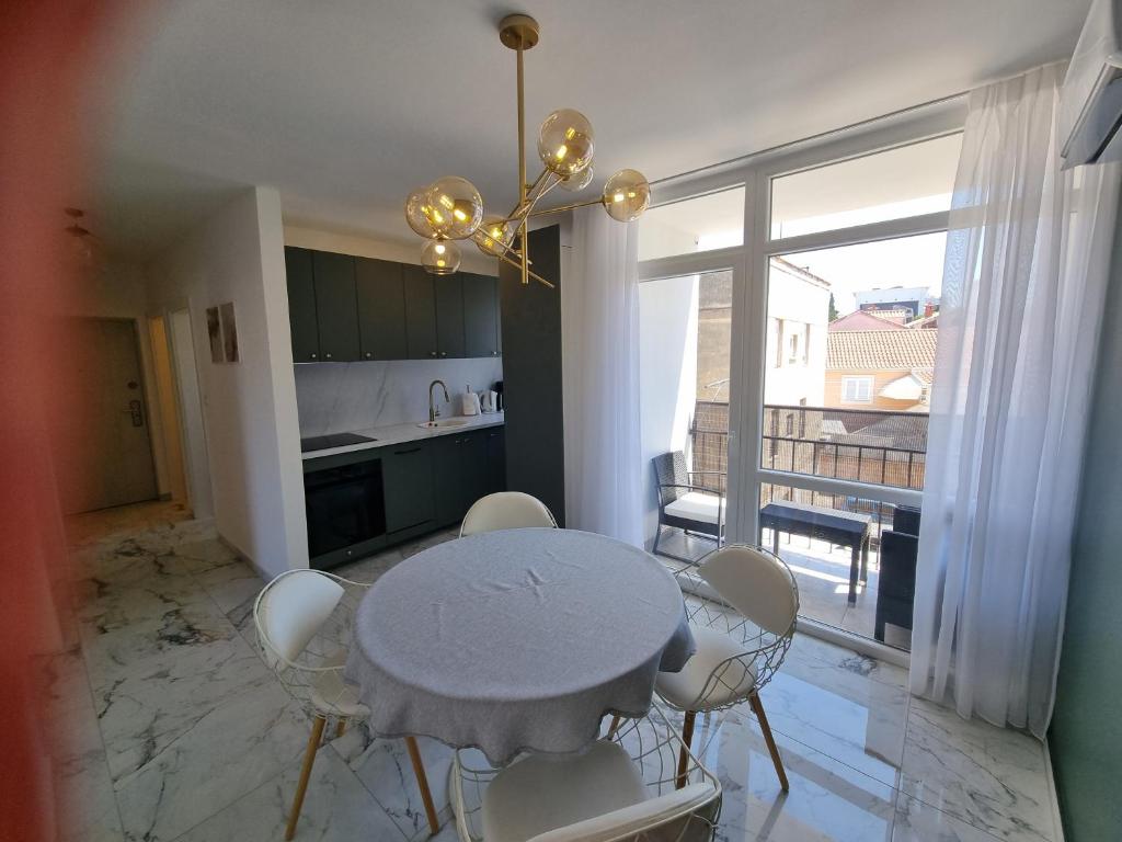 a kitchen with a table and chairs and a kitchen with a window at Apartment with view on city marine in Zadar