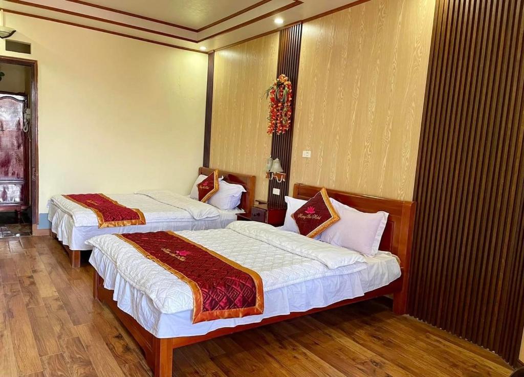 twee bedden in een kamer met houten vloeren bij Lotus Hotel in Sa Pa