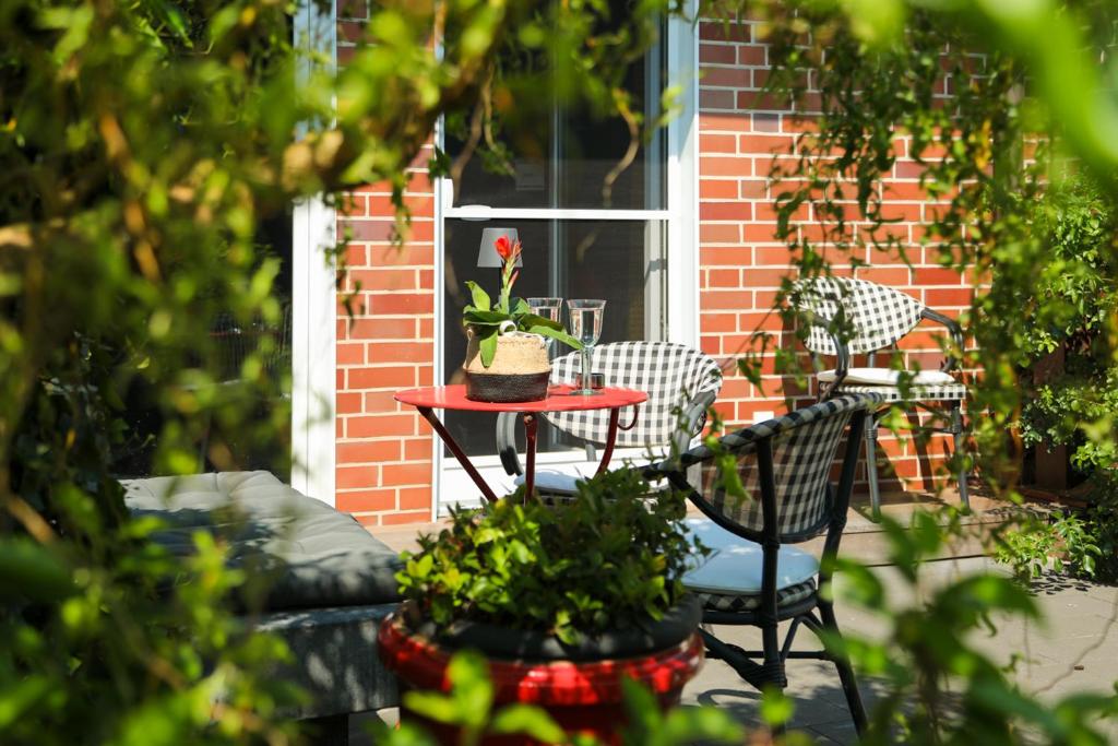 a patio with two chairs and a table with a plant at Marhold Apartments in Drensteinfurt