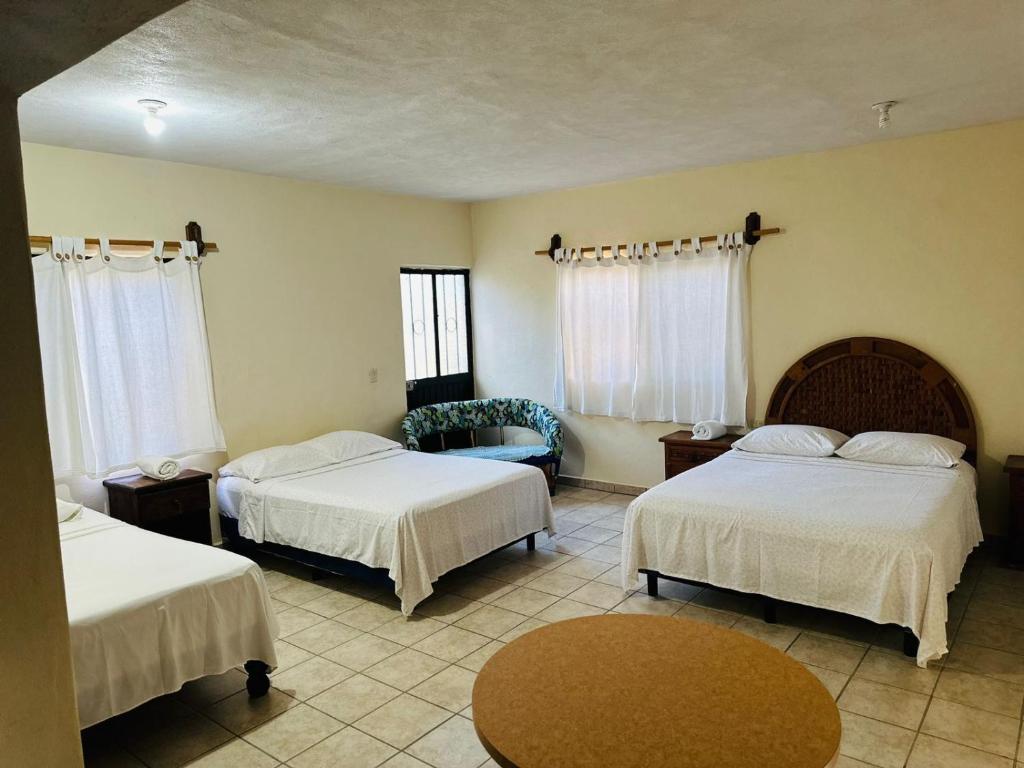 Habitación de hotel con 2 camas y mesa en Bungalow Cirujano, en Cabo Pulmo