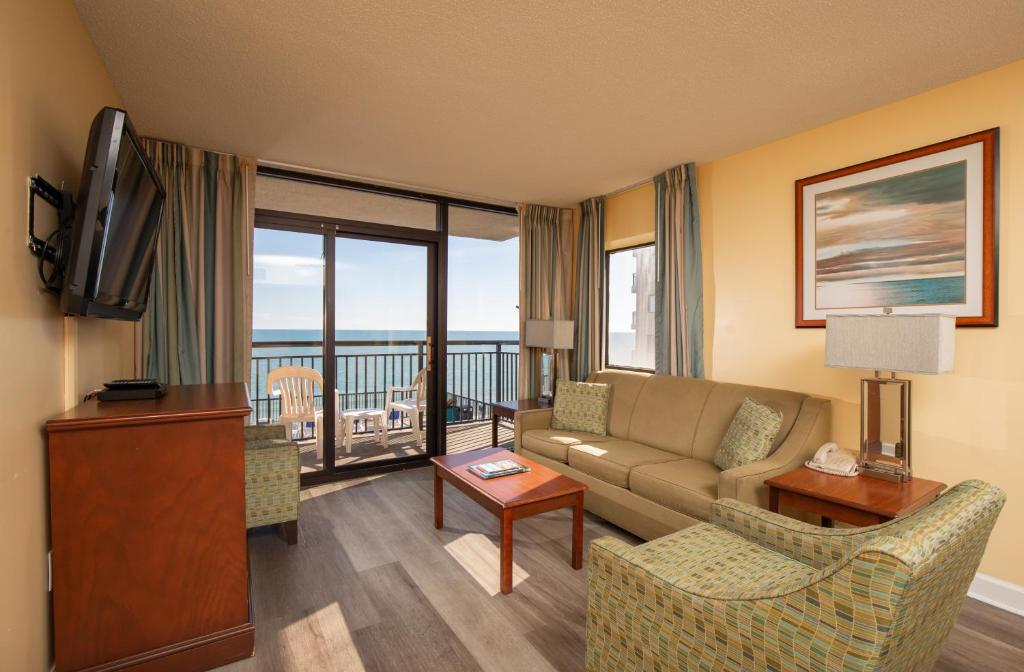 a living room with a couch and a television at Grande Shores Ocean Resorts Condominiums in Myrtle Beach