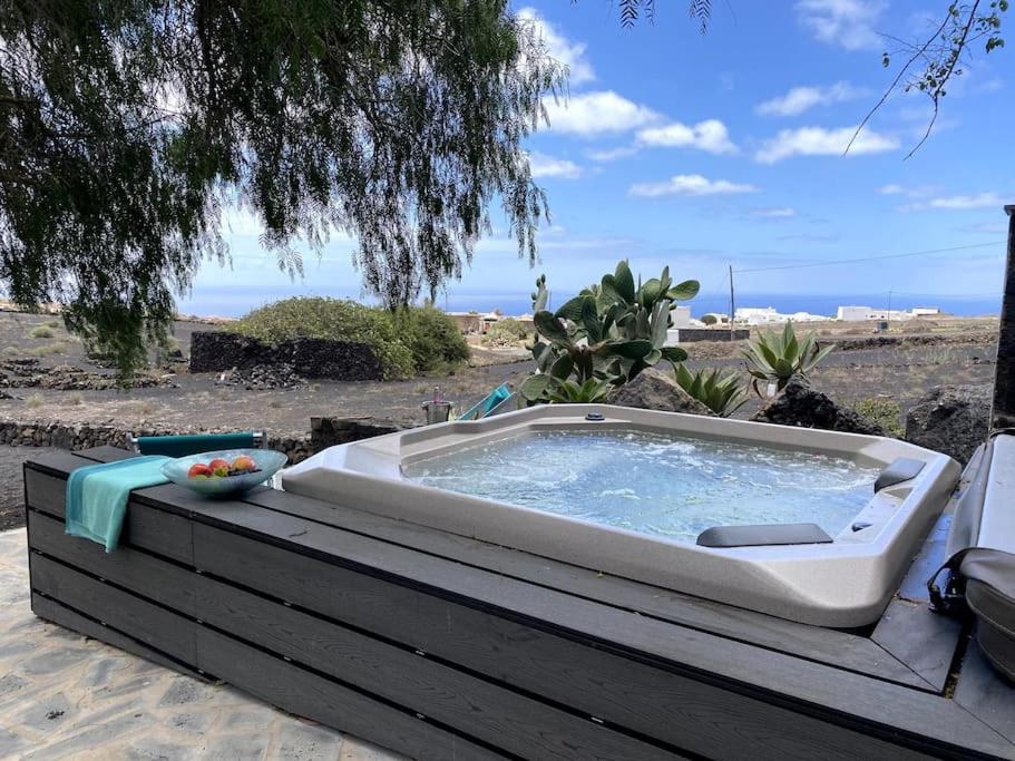 bañera de hidromasaje en la parte superior de una terraza de madera en Cosy finca, sea views, jacuzzi, en La Asomada