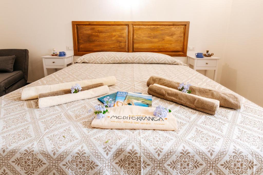 1 dormitorio con 1 cama con 2 toallas en Domo Mediterranea Affittacamere-Guest House, en SantʼAntìoco