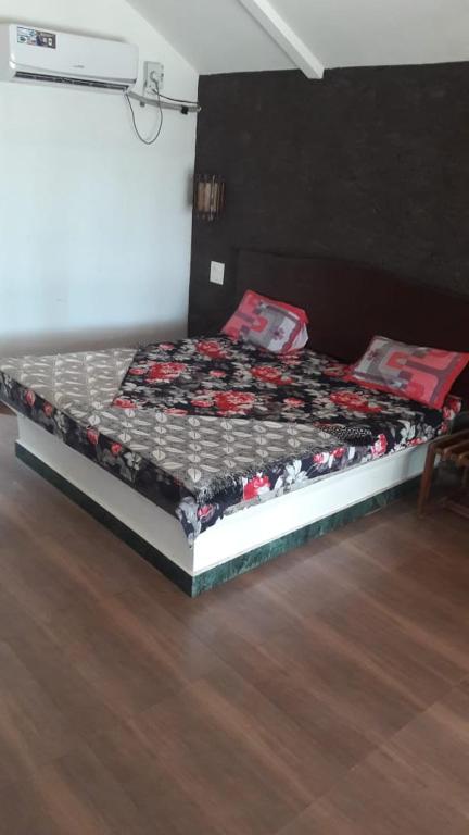 a bed in a room with a bedskirtspectspectspectspects at Manali Beach Resort in Bhogwe