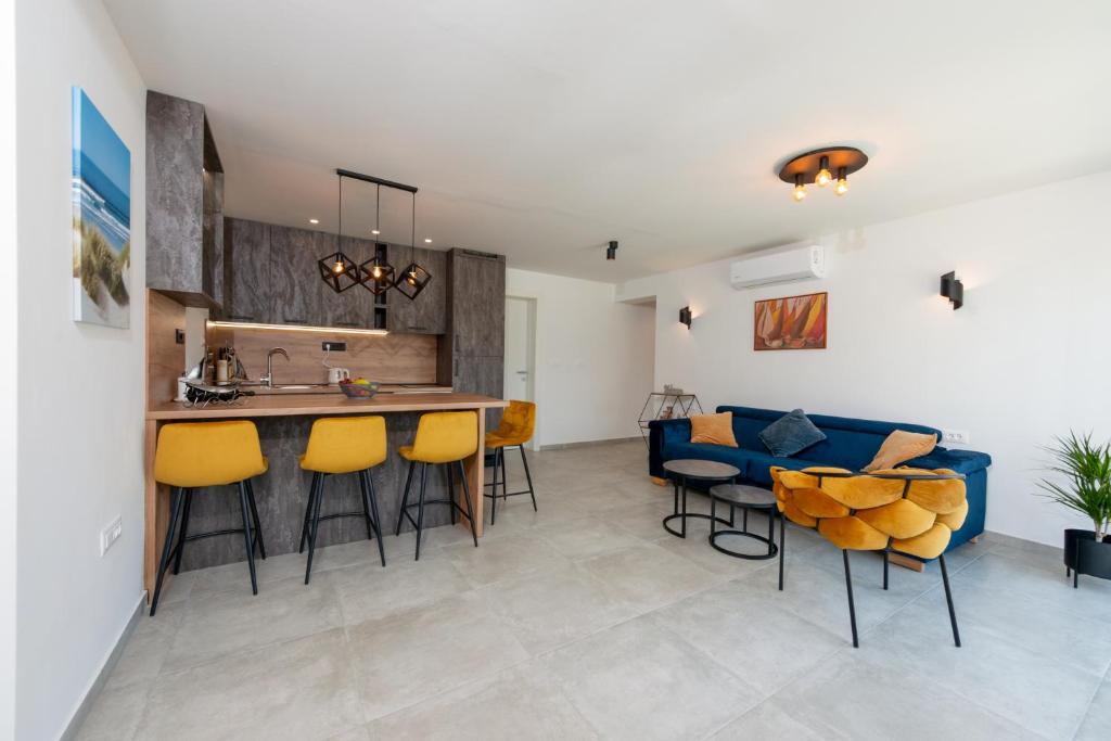 a kitchen and living room with a blue couch at Apartman Noa in Kastav