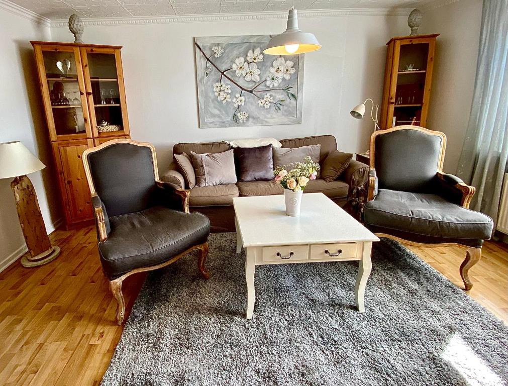 - un salon avec un canapé, deux chaises et une table dans l'établissement Gemütliche Ferienwohnung, à Sagard
