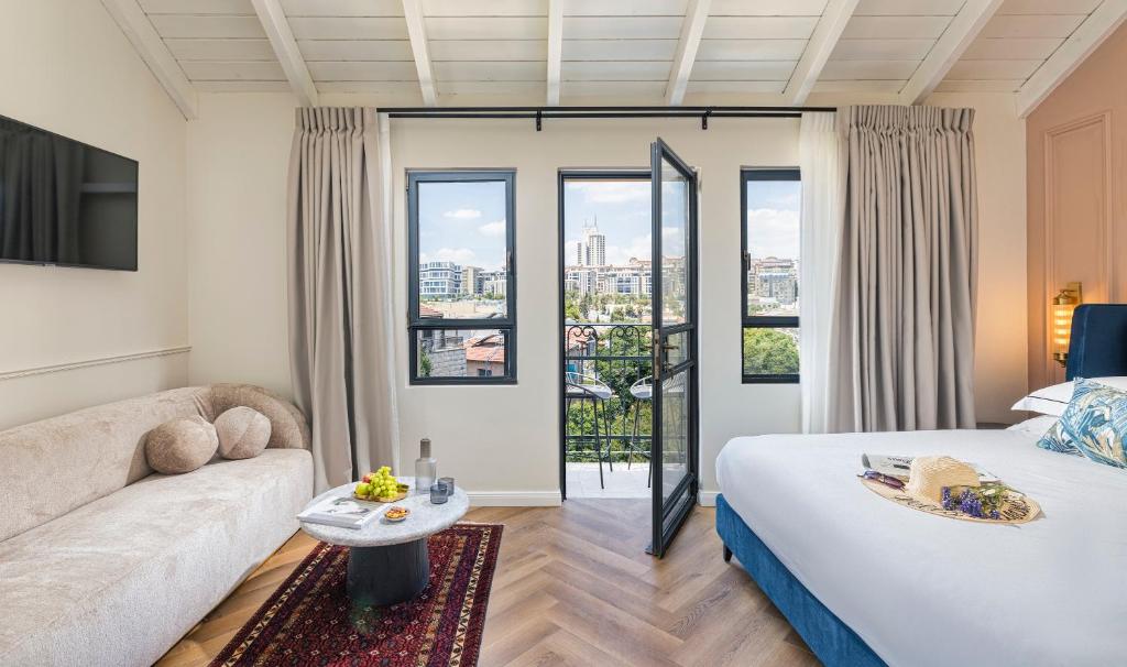 Habitación con cama, sofá y ventanas. en Damson - Machne Yehuda Hotel, en Jerusalén