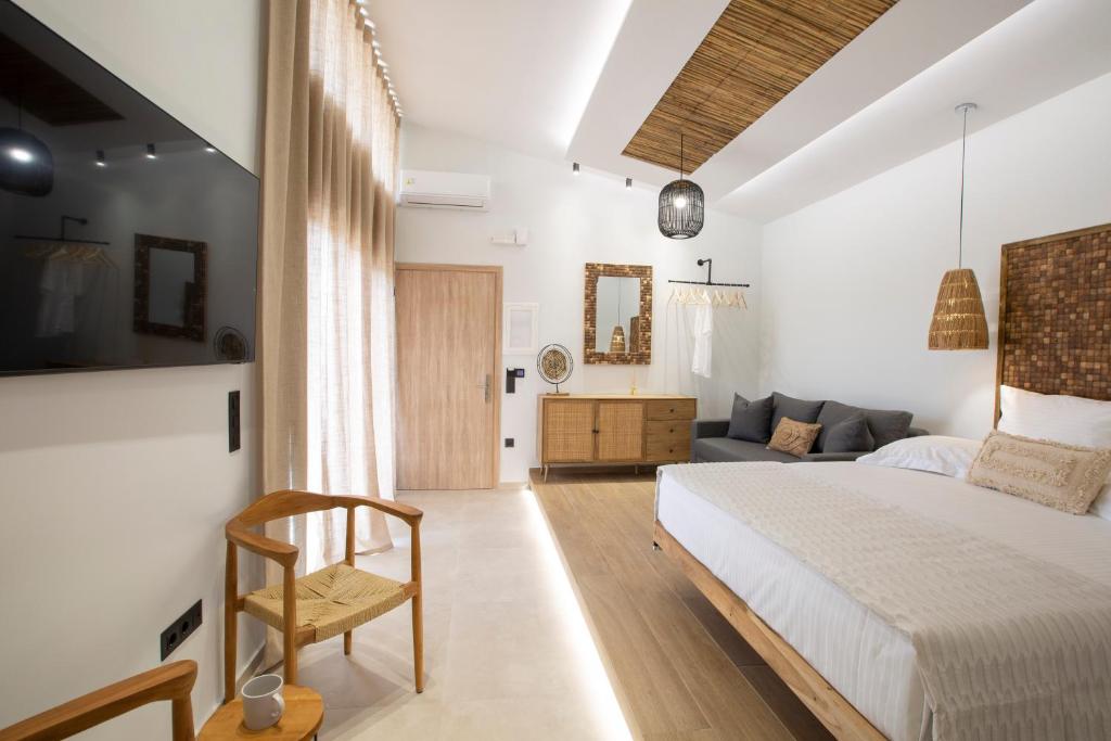 een slaapkamer met een bed en een bank bij ELFAM CITY SUITES in Lefkada