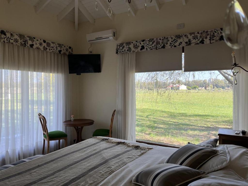 een slaapkamer met een bed en een groot raam bij Casa de campo en club privado in San Miguel del Monte