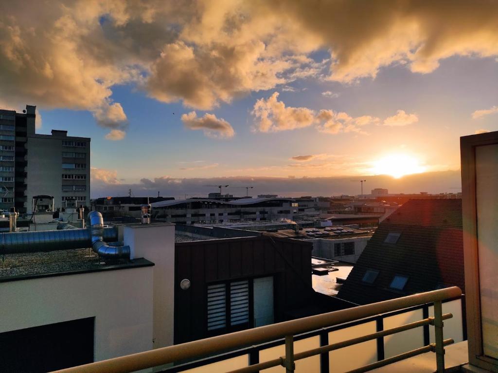 - une vue sur le coucher du soleil depuis le balcon d'un bâtiment dans l'établissement Appartement Terrasse Sud Dernier étage + Parking, au Havre