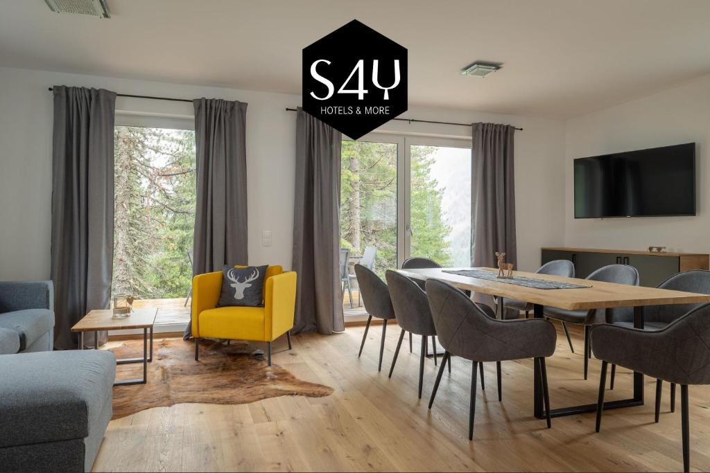 a living room with a dining room table and chairs at Turrach Chalet´s Grünsee in Turracher Hohe