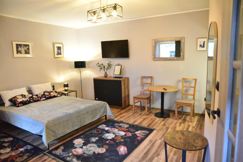 1 dormitorio con 1 cama, mesa y sillas en Hoffman Apartament, en Cracovia