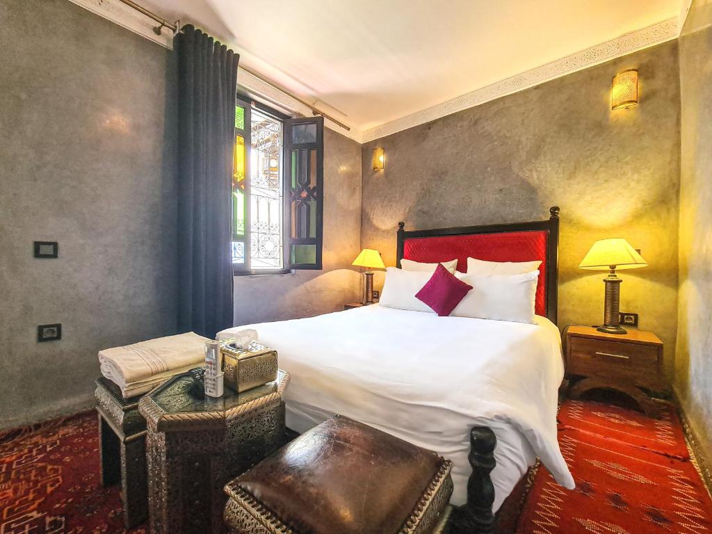 Un dormitorio con una cama grande y una ventana en Riad Jaime, en Marrakech