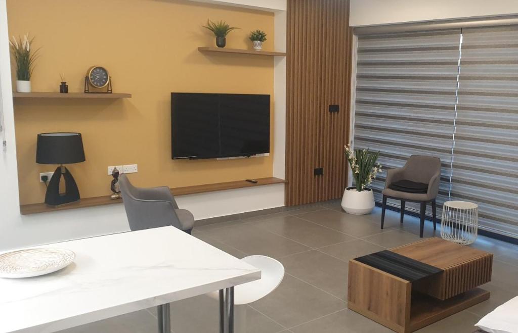een woonkamer met een tv en een tafel en stoelen bij New Smart Living-1 Bedroom Aglantzia, Nicosia in Aglantzia